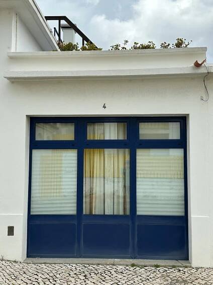 bezplatná Bílá budova s výraznými modrými dveřmi v portugalském prostředí, která předvádí architektonické kouzlo. Základová fotografie