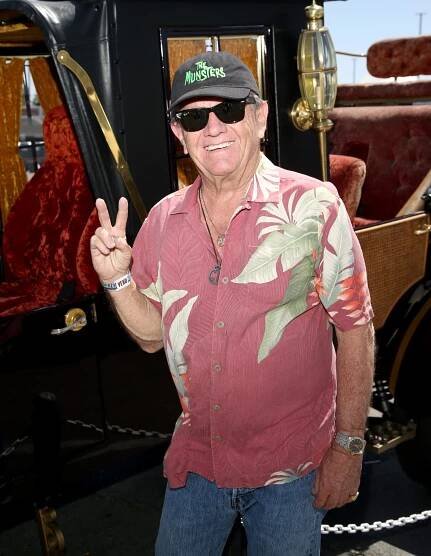 LAS VEGAS, NEVADA - APRIL 16: Actor Butch Patrick poses next to the The Munsters Mobile from the television show "The Munsters" during the car show at the 25th anniversary of the Viva Las Vegas Rockabilly Weekend at The Orleans Hotel & Casino at The Orleans Hotel & Casino on April 16, 2022 in Las Vegas, Nevada.
