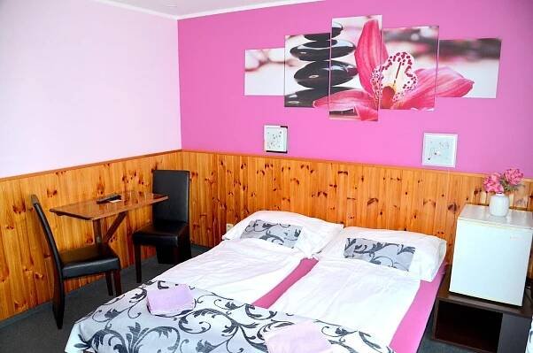 a bedroom with a bed and a desk and a table at Penzion Pod Boubínem in Kubova Huť
