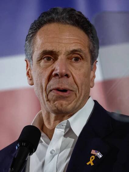 A tight profile of Andrew Cuomo, a lapel pin showing the flags of Israel and the United States together.