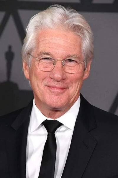an older man wearing glasses and a suit