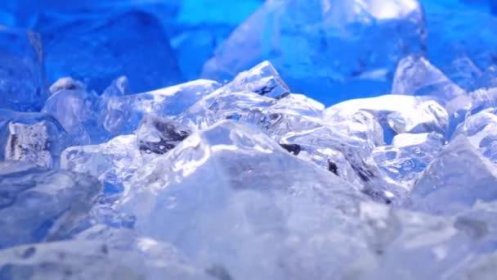 Kousky ledu leží na stole, modré osvětlení krásně leží nad fragmenty. Detailní záběr