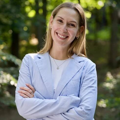 Cate smiling for a photo with trees in the background