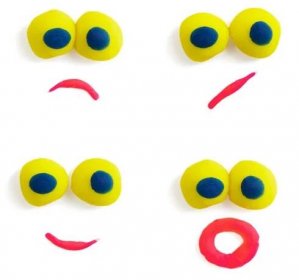 Čtyři ksichty - oči a ústa - vyrobené z různobarevné Plastelíny s různými výrazy na bílém pozadí. — Stock obrázek
