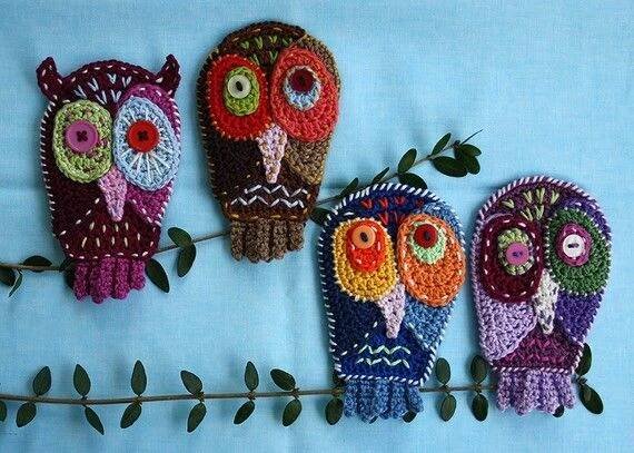 three crocheted owls sitting on top of a branch next to another one with leaves