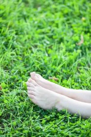 Bosý atraktivní ženské nohy v zelené trávě vertikální copyspace — Stock obrázek