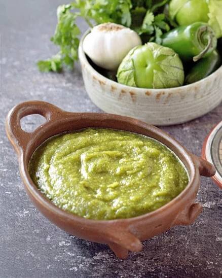 salsa verde in clay pig bowl with veggies in another bowl