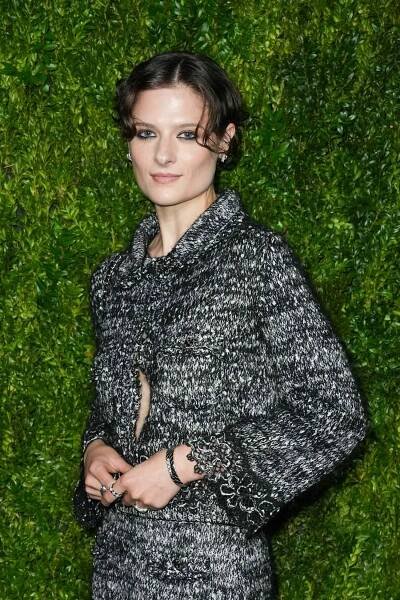 Louisa Jacobson wearing a two piece set standing in front of a grass wall