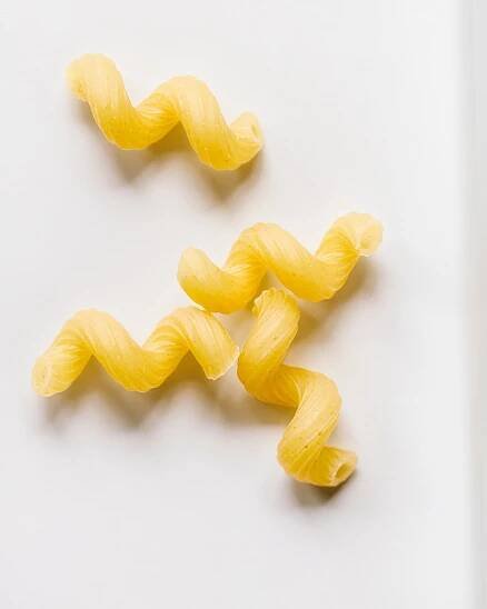 Cavatappi pasta on a white background.