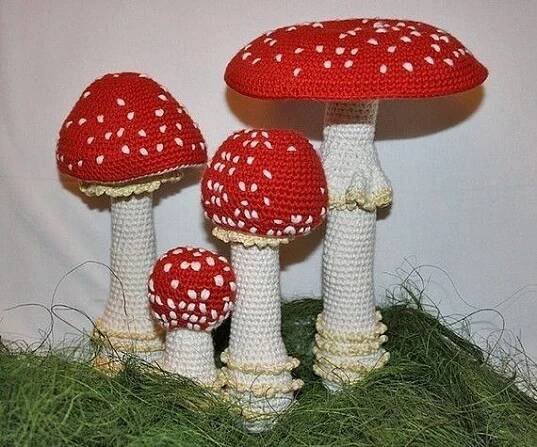three crocheted mushrooms sitting in the grass