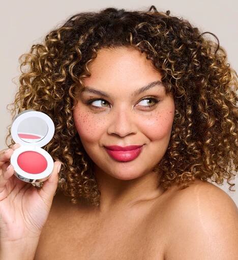 Model holding and wearing Colour Wonder Lip and Cheek Balm Rebel Red