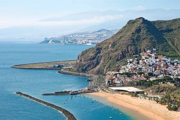 A stunning panoramic view of Santa Cruz de Tenerife's coastline, showcasing mountains and the sea | MSC Cruises
