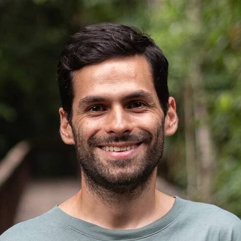 Image of Alejandro Chica, outside in a blue Earthshot shirt against a blurry natural background
