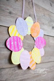 a paper heart wreath hanging on a wooden wall