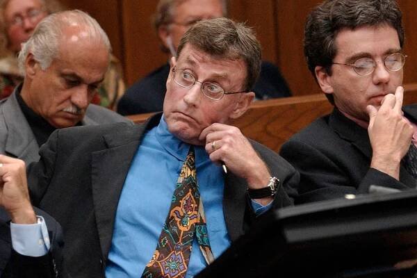 Michael Peterson, center, watches as prosecutor David Saacks, not pictured, argues why gay pornography and e-mail soliciting sex with another man taken from Peterson's home computer should be presented to the jury during Peterson's murder trial, Thursday Aug. 7, 2003, in Durham, N.C. Peterson is flanked by lead defense counsel David Rudolf, left, and co-counsel Thomas Maher, right. Superior Court Judge Orlando Hudson ruled the material was relevant because it could address a motive for the first-degree murder charge against Peterson, who is accused of killing his wife, Kathleen.
