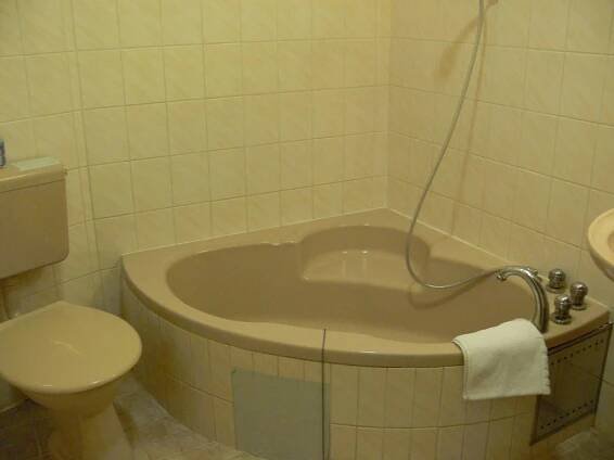 a bath tub in a bathroom with a toilet at Penzion Oaza in Luhačovice