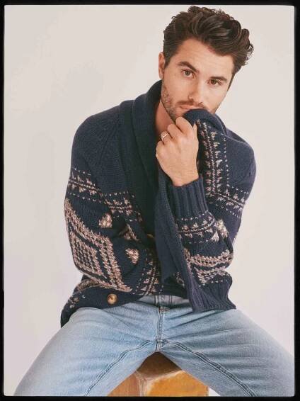 Chase Stokes cuddling in a blue patterned sweater.