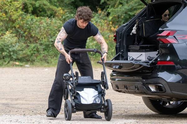 Tom Grennan loading a stroller into a car.