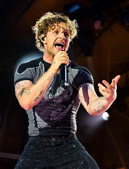 Tom Grennan performing at a concert.