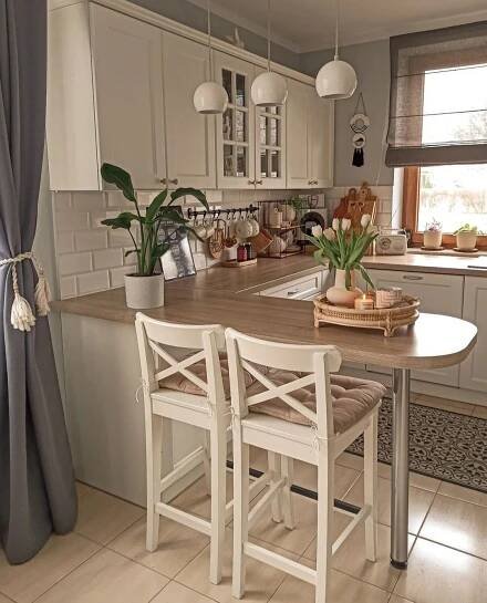 a kitchen with a table and chairs next to a window in the middle of the room