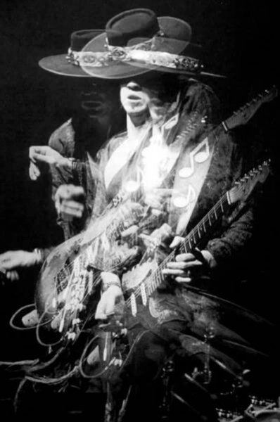 a man in a cowboy hat playing an electric guitar