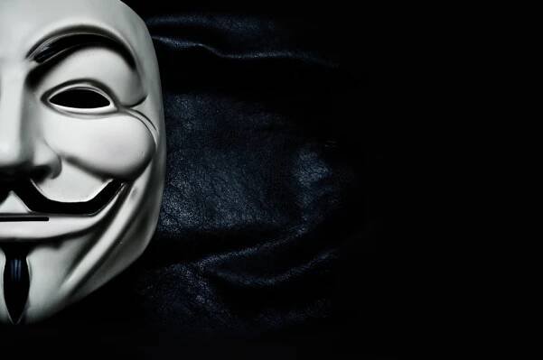 Paříž - Francie - 18. ledna 2015 - Vendetta masku na černém pozadí. Tato maska je známý symbol pro on-line hacktivist skupiny Anonymous — Stock obrázek