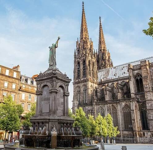 Une statue devant une cathédrale majestueuse près des Hôtels Oceania