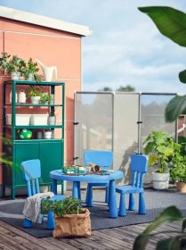 Zóna pro děti na terase s modrým dětským stolem a židličkami MAMMUT. Za nimi je zelená skříňka KOLBJÖRN.