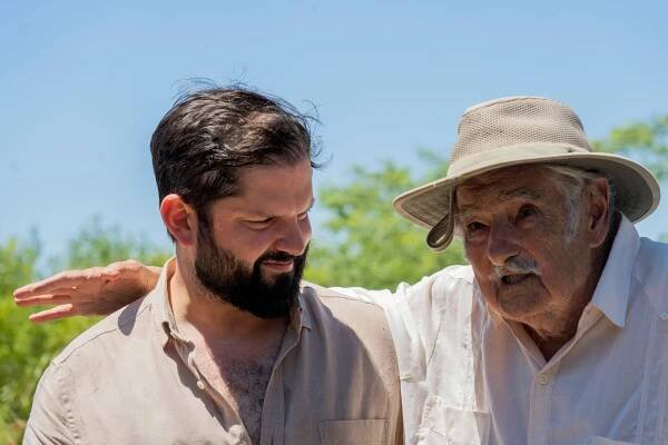 Chile's President Gabriel Boric, left, next to Mujica as he speaks to the press at his farm outside Montevideo, Monday, Feb. 3, 2025.
