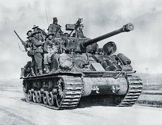 Australian soldiers ride an M4A3E8 Sherman tank 50 miles north of the North Korean capital of Pyongyang during the U.N