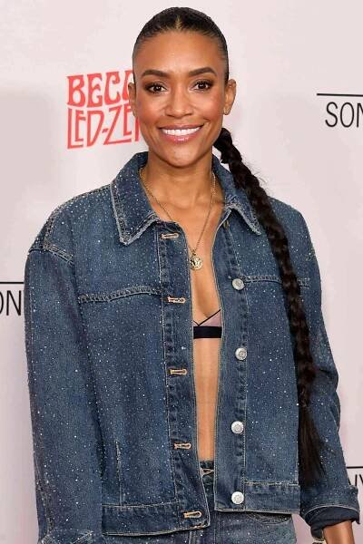 Annie Ilonzeh smiling, wearing a denim jacket and long braided hairstyle.