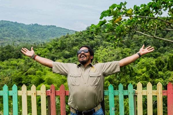A photo of Rohan Marely, the Son of legend Bob Marley, greeting a beautiful day on his coffee plantation in the Blue Mountains of Jamaica. He is smiling and in a great mood.