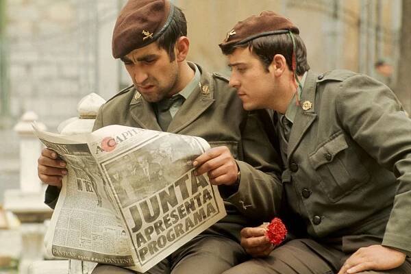 Two Portuguese soldiers reading a newspaper to find out the latest on the coup.