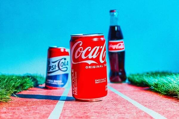 Cans and a bottle of soda on a running track.