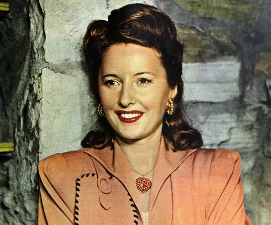 Barbara Stanwyck 1943 in orange top and jewelry