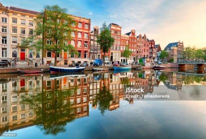 Krásný amsterdamský západ slunce. Typické staré holandské domy na mostě a kanálech na jaře, Nizozemsko - Bez autorských poplatků Amsterdam Stock fotka