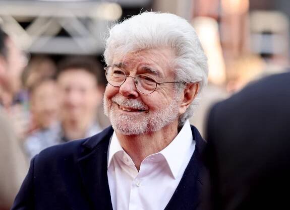 George Lucas walks a red carpet.