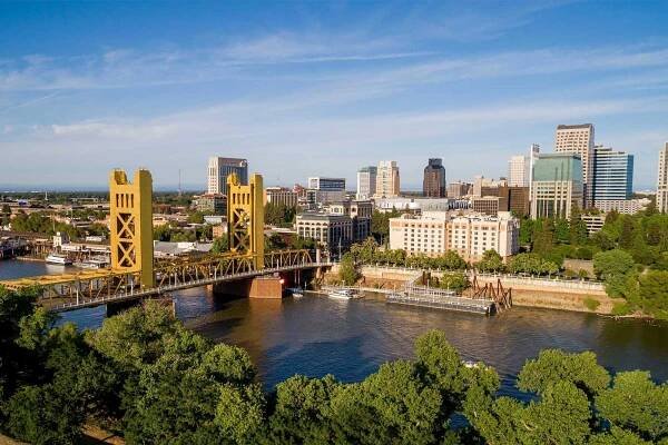 High quality stock aerial view photo of Sacramento's Tower Bridge and the Sacramento River, looking towards the Capitol mall and building.