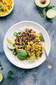 Mango Chicken is easy to throw together and mega flavorful! This delicious recipe starts with marinated chicken (either breast or thighs) and is topped with cilantro-lime mango salsa.   Recipe via Chelsea's Messy Apron #mango #chicken #avocado #grilled #dinner #easy