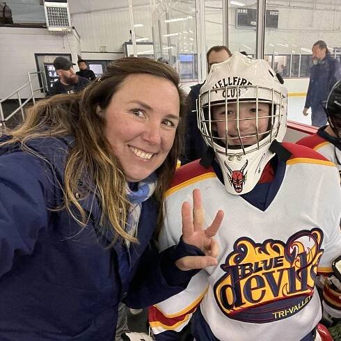 Our hockey family posing with our son who plays goalie at a tournament