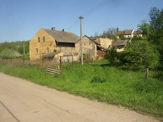 Jedna z usedlostí s kostelem sv. Václava v pozadí