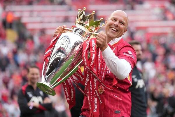 Liverpool manager Arne Slot holding the Premier League trophy.