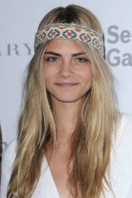 Model Cara Delevingne bändigt ihre wilde Mähne mit einem bunten Haarband im Hippie-Style.