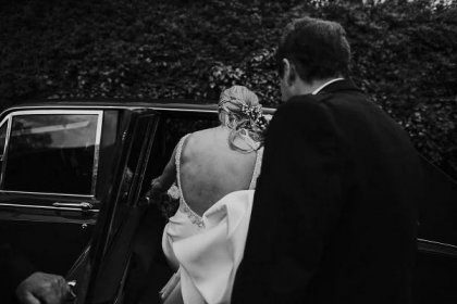 bride getting into the car to go to her wedding ceremony at melrose abbey she wears a backless wedding dress 