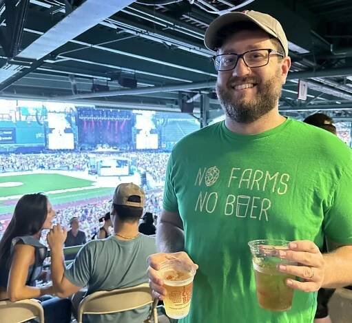 Matt Harding, seen here holding two beers at Fenway Park, is the man behind the beer at Time Out Market Boston.