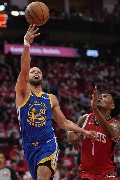 Golden State Warriors guard Stephen Curry drives past Houston Rockets forward Amen Thompson.