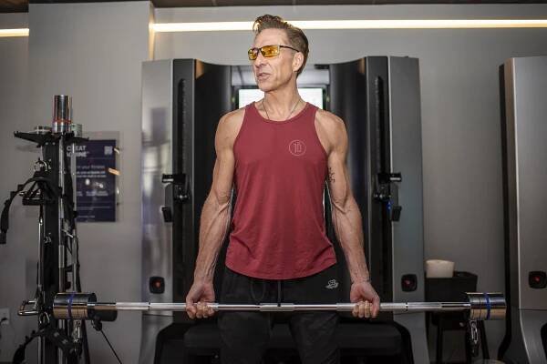 Dave Asprey lifts weights at a gym.