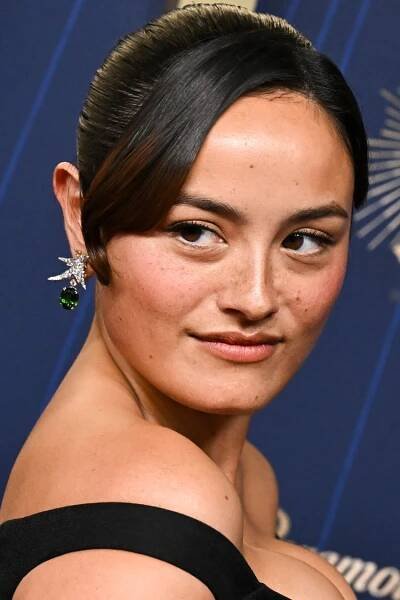 Chase Sui Wonders posing at an event wearing formal attire and an earring