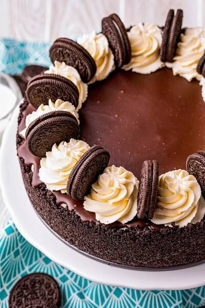 Decorated oreo cheesecake overhead topped with ganache, whipped cream and Oreos.