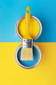 Can of yellow paint with brush on yellow and blue background. Top view, redecorating in Ukrainian flag colors. — Stock Image